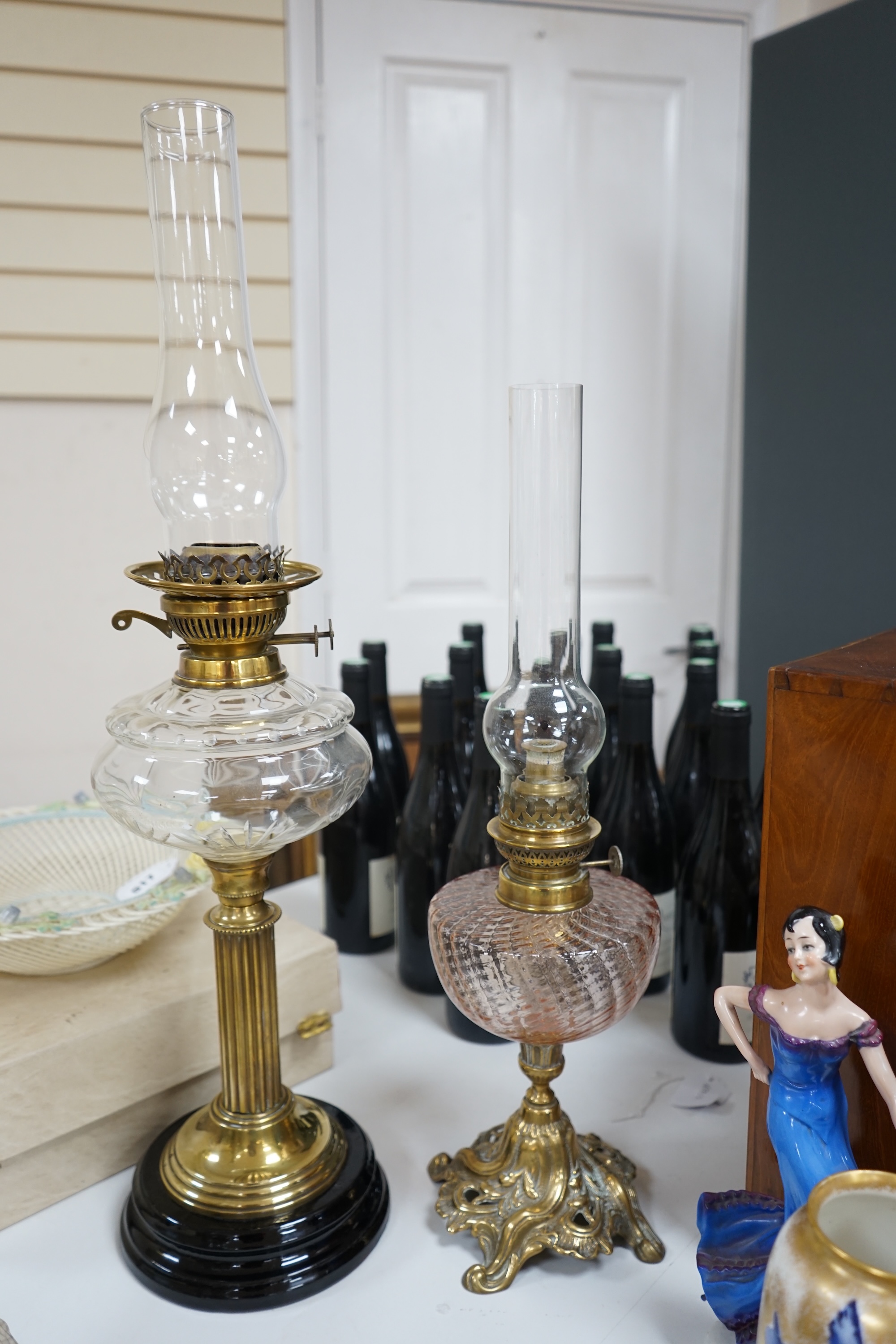 Two brass oil lamps with glass spirit tanks, tallest 67cm. Condition - good.